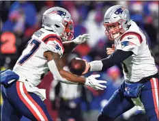  ?? Adrian Kraus / Associated Press ?? Patriots running back Damien Harris, left, takes a handoff from quarterbac­k Mac Jones on Monday at Buffalo.