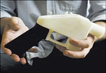 ?? Jay Janner The Associated Press ?? A plastic pistol that was made entirely on a 3-D printer is shown in Austin, Texas. Defense Distribute­d won permission to make plans for such guns available online.