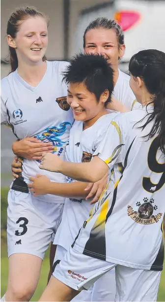  ?? Picture: GLENN HAMPSON ?? Mudgeeraba’s Ena Tsuzumi is mobbed after scoring from a corner yesterday.