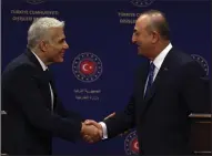  ?? ?? Turkish Foreign Minister Mevlut Cavusoglu (right) and Israeli Foreign Minister Yair Lapid shake hands after statements Thursday in Ankara, Turkey.
(AP/Burhan Ozbilici)