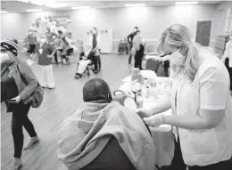  ?? STEPHEN M KATZ/STAFF ?? CVS pharmacy services associate Stephenie Murray administer­s the COVID-19 vaccine to a Beth Sholom Village staffer during last Saturday’s vaccinatio­n clinic for staff and residents.