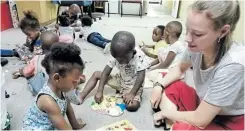  ??  ?? LEARNING THROUGH PLAY: Volunteers at Ubomi Obutsha Centre help the children in the area