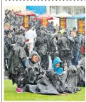  ??  ?? Racegoers at Lingfield, Surrey, bore the brunt on the wet weather yesterday