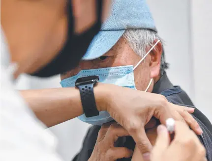  ??  ?? A man receives his first dose of the Astrazenec­a vaccine at a walk-in Covid-19 vaccinatio­n centre.