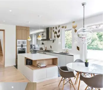  ??  ?? The kitchen is modern and whimsical. A backsplash features triangular tiles flowing down toward cabinetry imported from Kvanum, a Swedish company. The faucets are by Denmark’s Arne Jacobsen, while the pendant lights over the counter are by Denmark’s Louis Poulsen. “We gravitated toward Danish and Dutch style throughout the house,” explains Dan