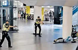  ?? AP ?? Dutch officers close in on a wounded 19-year-old Afghan man police shot after he allegedly stabbed two American tourists Friday at the main train station in Amsterdam.