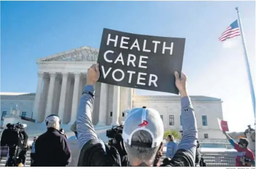  ?? MICHAEL REYNOLDS / EFE ?? Varias personas protestan ayer fuera del Tribunal Supremo en Washington a favor del ‘Obamacare’.