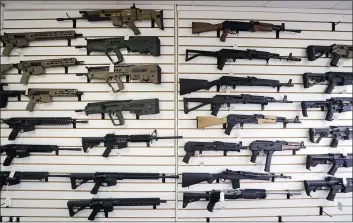  ?? ELAINE THOMPSON — THE ASSOCIATED PRESS FILE ?? Semi-automatic rifles fill a wall at a gun shop in Lynnwood, Wash.