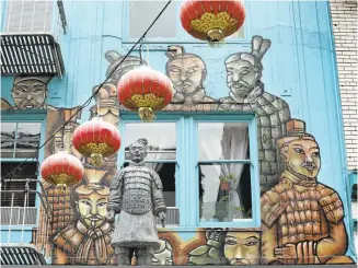  ?? LAURA A. ODA/STAFF ?? A mural of the Terracotta Warriors complement­s the replica statues that seem to stand guard on the second floor of a building in San Francisco’s Chinatown.