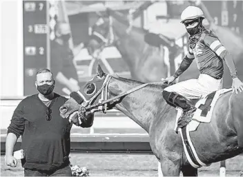  ?? BENOIT PHOTO ?? Trainer Mark Glatt holds Zestful, who gave the trainer his 1,000th career victory on Friday at Del Mar.