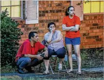  ??  ?? Enrique, Elizabeth and Sofia Salazar (from left) watch what remains of their apartment. In June, the DeKalb County School District bought the 104-unit complex as part of a plan to build a new elementary school in the Cross Keys cluster of schools.