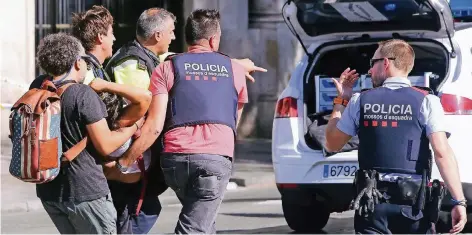  ?? FOTO: DPA ?? Polizisten, Sanitäter und Passanten tragen nach dem Anschlag in Barcelona eine verletzte Frau über die Straße.