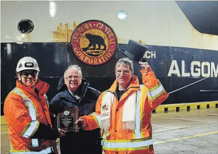  ?? DAVE JOHNSON
THE WELLAND TRIBUNE ?? Port Colborne Mayor John Maloney presented a plaque and a top hat to Algoma Equinox Capt. Peter Shultz, right, and chief engineer Francois Tremblay, left, Friday morning at Lock 8 on the Welland Canal at Port Colborne.
