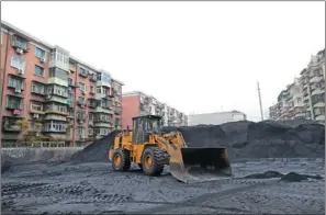  ??  ?? Coal stockpiled in an open space in the Yibaibeili community in Tianjin.