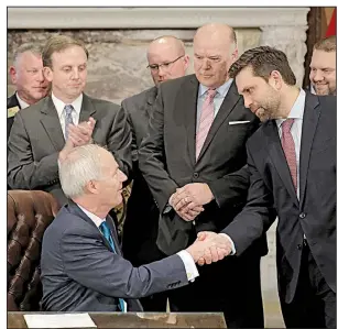  ?? Arkansas Democrat-Gazette/JOHN SYKES JR. ?? Gov. Asa Hutchinson shakes hands with state Sen. Jonathan Dismang on Tuesday after signing the measure cutting taxes for the state’s top earners. Dismang sponsored the bill.
