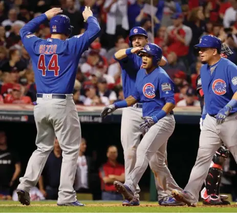  ?? JAMIE SQUIRE/GETTY IMAGES ?? Chicago’s Addison Russell, second from right, hit a grand slam to give the Cubs a big lead early Tuesday. Game 7 is Wednesday night.