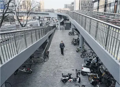  ?? /GETTY IMAGES ?? Un residente camina por una desolada calle de Beijing, China.