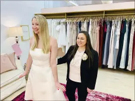  ?? GILDED SOCIAL VIA AP ?? Owner Tanya Rutner Hartman helps customer Cristin Lee try on a gown at the Gilded Social, a bridal shop in Columbus, Ohio, earlier this month. Although weddings and other big celebratio­ns are going back on the calendar, business owners who make those events happen expect a slow recovery from the impact of the pandemic.