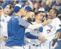  ?? CP PHOTO ?? Toronto Blue Jays’ Curtis Granderson­gets mobbed by teammates after he hit a walkoff home run to beat the Boston Red Sox 4-3 in the 10th inning Tuesday night in Toronto.