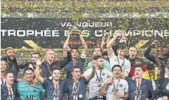  ?? AFP ?? PSG captain Thiago Silva holds the trophy as he celebrates with teammates.