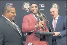  ?? SUE OGROCKI — THE ASSOCIATED PRESS ?? Nelson Cruz, middle, receives the 2021 Roberto Clemente Award from MLB commission­er Rob Manfred, right, as Luis Roberto Clemente, son of the late Hall of Famer Roberto Clemente, looks on before Wednesday’s game.