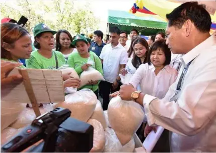 ?? Jaso/Pampanga PIO ?? BIGASAN. Capitol.---JunTUPAD beneficiar­ies line up for cheap NFA rice yesterday during the Pampanga Day Bigasan at