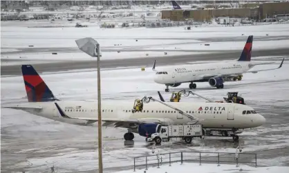  ??  ?? A crew works to deice a plane at Minneapoli­s-St Paul internatio­nal airport. Photograph: Stephen Maturen/Getty Images