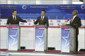  ?? AP photo ?? Florida Gov. Ron DeSantis (from left), businessma­n Vivek Ramaswamy and Sen. Tim Scott, R-S.C., argue a point during a Republican presidenti­al primary debate hosted by FOX Business Network and Univision on Wednesday, at the Ronald Reagan Presidenti­al Library in Simi Valley, Calif.