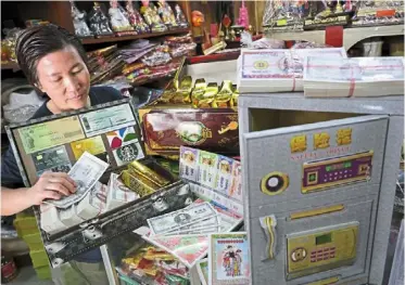  ?? — chan BOON Kai/the star ?? Currency of the afterlife: ang showing the moneytheme­d offerings for sale at her shop in Lebuh Kimberley, George Town.
