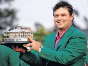  ?? AP PHOTO/CHRIS CARLSON ?? Patrick Reed holds the championsh­ip trophy after winning the Masters golf tournament Sunday in Augusta, Ga.