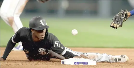  ?? ORLIN WAGNER/ AP ?? The White Sox’ Tim Anderson hangs on to second base as the ball gets past Royals shortstop Alcides Escobar during the eighth inning Saturday in Kansas City.