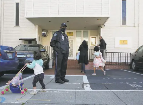  ?? Lea Suzuki / The Chronicle ?? Security officer Billy Burke works at the Indian Consulate as Mithali Kamath, 1, pushes her stroller along Arguello Boulevard.
