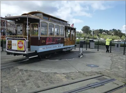  ?? PHOTOS BY ERIC RISBERG — THE ASSOCIATED PRESS ?? A cable car operator looks out toward the Golden Gate Bridge while standing at the near-empty Hyde Street turnaround Monday in San Francisco. Officials in six San Francisco Bay Area counties issued a shelter-in-place mandate Monday affecting nearly 7million people, including the city of San Francisco itself.