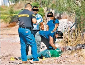  ??  ?? Peritos examinan el cadáver de un hombre en Ciudad Juárez.