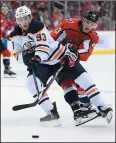  ?? AP PHOTO/NICK WASS ?? Washington Capitals right wing Dmitrij Jaskin, right, battles for the puck against Edmonton Oilers centre Ryan NugentHopk­ins, left, during an NHL game Monday in Washington.