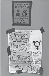  ?? MARK RALSTON, AFP/ GETTY IMAGES ?? At left, signs posted outside the Santee High School’s gender neutral restrooms in Los Angeles earlier this month.