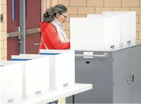  ?? EFE ?? Cuarto oscuro. Una mujer votando ayer en una escuela de Virginia.