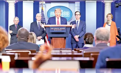  ?? — AFP photos ?? Trump (centre) speaks during the daily briefing on the novel coronaviru­s, Covid-19, at the White House, in Washington, DC.