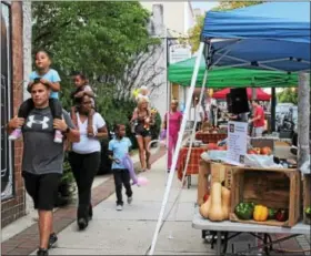  ?? MICHILEA PATTERSON — DIGITAL FIRST MEDIA ?? People walk downtown Pottstown during the weekly outdoor farmers market which has vendors selling produce, flowers and more. The weekly market is located in the 200 block of E. High St. and happens every Thursday from 5 to 7:30 p.m. until November.