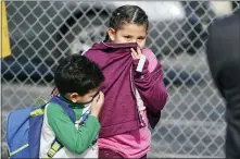  ?? SCOTT VARLEY — THE ORANGE COUNTY REGISTER VIA AP ?? Children covering their noses and mouths leave school where multiple people were treated for jet fuel exposure at Park Avenue Elementary School in Cudahy on Tuesday. A jet returning to LAX dumped its fuel over the neighborho­od and the school. Affected people at the school were treated for skin and eye irritation. No patients were transporte­d to hospitals.