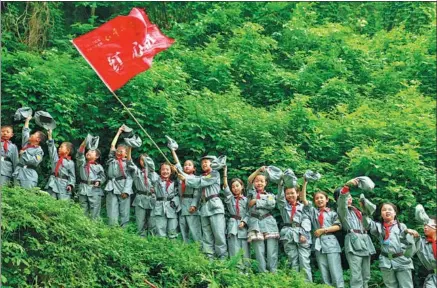  ?? QIU HAIYING / XINHUA ?? Wearing Red Army uniforms, students from a primary school in Huaying city, Sichuan province, experience the Red Army’s Long March by climbing a steep hill.