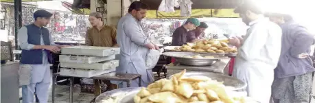  ?? ?? Attock: On the occasion of Ramadan, fasting people buy samosas and pakoras. — NNI