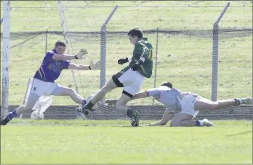  ??  ?? Meath star Daire Rowe scores a goal despite the best efforts of Brian Miley and Ian Murphy.