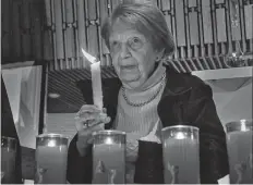  ?? JOHN KENNEY POSTMEDIA NEWS ?? Holocaust survivor Nettie Herscher holds a candle during a ceremony at the Tifereth Beth David Jerusalem Congregati­on in the Côte-St-Luc area of Montreal on Wednesday.
•