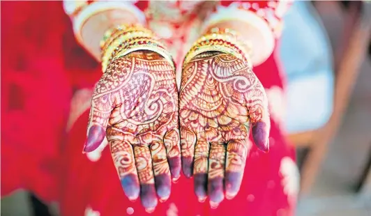  ??  ?? The traditiona­l henna tattoo is painted on the hands of an Asian bride. Forced marriages are still common in Asian culture but, increasing­ly, young Asians growing up in Britain are rejecting their parents’ wishes and declaring they want to choose their own partners