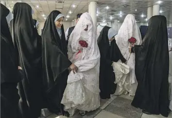  ?? Ebrahim Noroozi Associated Press ?? AFGHAN girls help brides get ready for a mass wedding ceremony in Kabul on Internatio­nal Women’s Day. Taliban-ruled Afghanista­n has become the world’s most repressive country for women and girls, the U.N. says.
