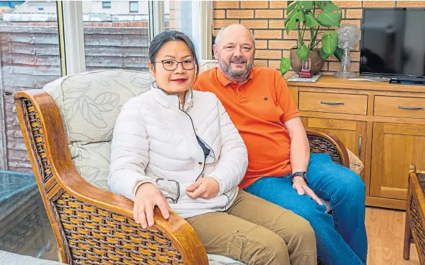  ??  ?? VICTIM OF BUREAUCRAC­Y: Chailai, pictured at home with her husband Ally, is a British citizen and has lived and worked in Dundee for 11 years.