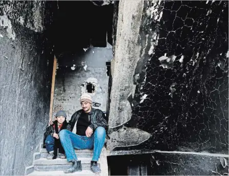  ?? HASSAN AMMAR THE ASSOCIATED PRESS FILE PHOTO ?? Mohammed Bayraqdar poses with his son Abdul-Awal at their burned house in Khaldiyeh, one of the worst damaged areas in Homs, Syria.