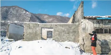  ??  ?? Picture taken by Internatio­nal Federation of Red Cross and Red Crescent Societies (IFRC) on Dec 7 and released yesterday shows an IFRC staff member showing the water level on a building damaged by floods in Musan County in North Korea’s North Hamgyong...