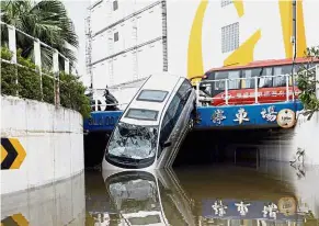  ??  ?? The aftermath: (Left) A family walking through a flooded street in Dongguan, Guangdong province. (Above) A vehicle hanging precarious­ly off a bridge in Macau, presumably blown there by strong winds. — Reuters